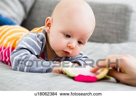 Picture - Baby boy staring at toy. Fotosearch