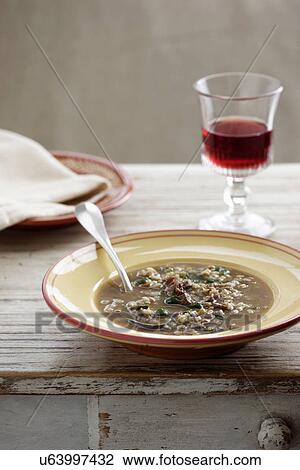 Stock Image - Beef and barley soup with glass of red wine. Fotosearch
