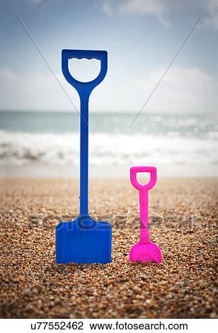 Blue and pink spades standing in sand at beach View Large Photo Image Stock Image - Blue and pink spades standing in sand at beach. Fotosearch