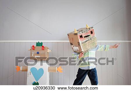 Stock Image - Boy with box covering head and homemade toy robot. Fotosearch
