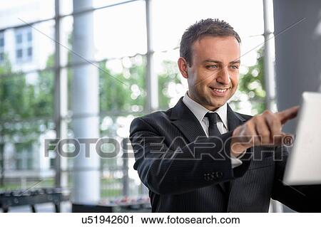 Businessman interacting with digital tablet screen View Large Photo Image Stock Image - Businessman interacting with digital tablet screen. Fotosearch