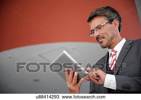 Stock Image - Businessman using digital tablet. Fotosearch