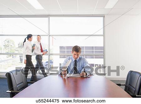 Businessman working at desk, colleagues in background View Large Photo Image Stock Photography - Businessman working at desk, colleagues in background. Fotosearch