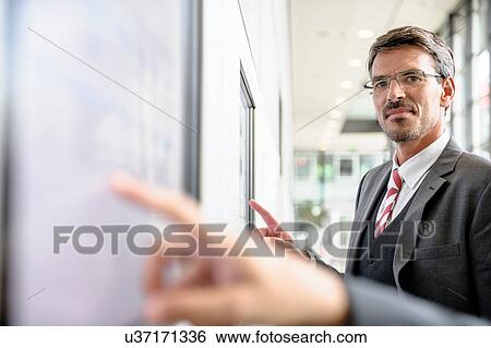Stock Photograph - Businessmen interacting with touch screens. Fotosearch