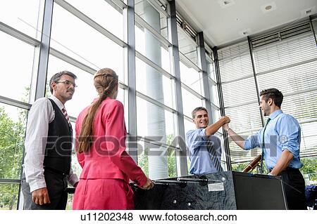 Stock Photo - Businessmen winning at table football in lobby. Fotosearch