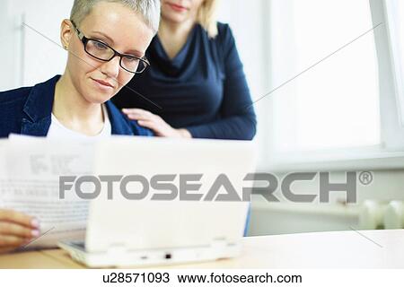 Businesswoman with paperwork with colleague's hand on shoulder View Large Photo Image Stock Image - Businesswoman with paperwork with colleague's hand on shoulder. Fotosearch