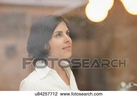 Candid portrait of young female taken through window View Large Photo Image Stock Image - Candid portrait of young female taken through window. Fotosearch