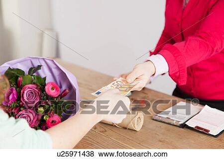 Stock Photo - Close up of customer buying bouquet from florist. Fotosearch
