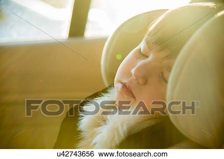 Stock Photograph - Close up of young girl sleeping in car. Fotosearch