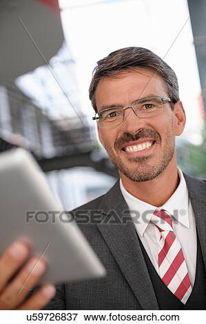 Stock Photo - Close up portrait of businessman holding digital tablet. Fotosearch