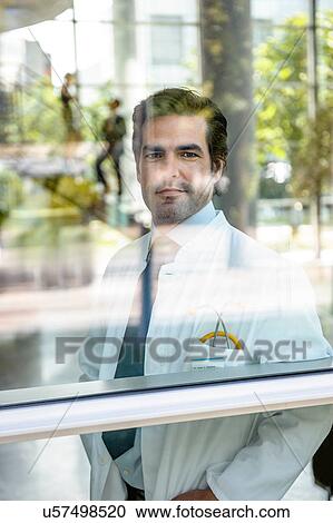 Close up portrait of male doctor looking out of window View Large Photo Image Stock Image - Close up portrait of male doctor looking out of window. Fotosearch