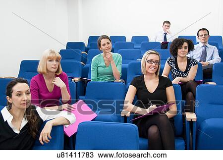 Stock Image - Colleagues sitting for presentation. Fotosearch