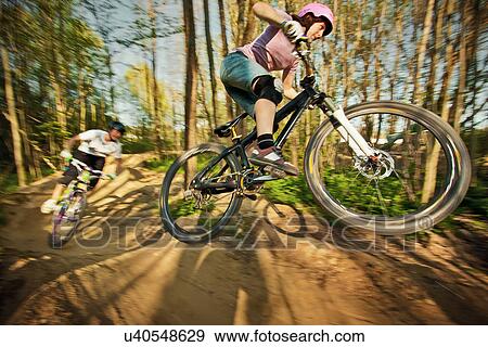 Cyclists riding on dirt bike course View Large Photo Image Stock Photo - Cyclists riding on dirt bike course. Fotosearch