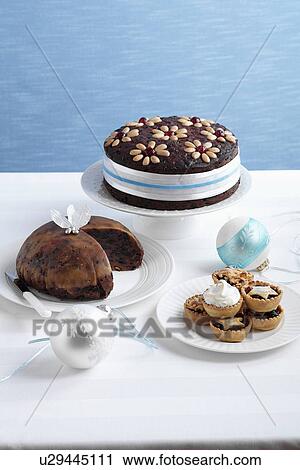 Stock Image - Decorated fruitcake and mince pies. Fotosearch