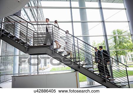 Stock Photography - Doctors and businessmen walking up hospital staircase. Fotosearch