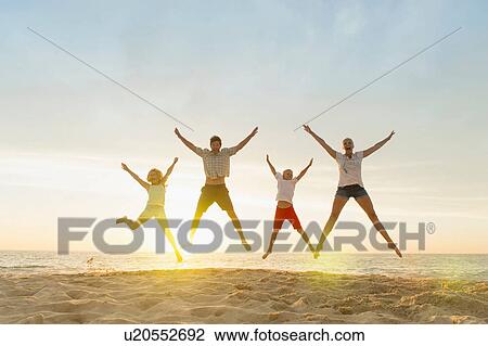 Family doing star jumps on beach View Large Photo Image Stock Image - Family doing star jumps on beach. Fotosearch
