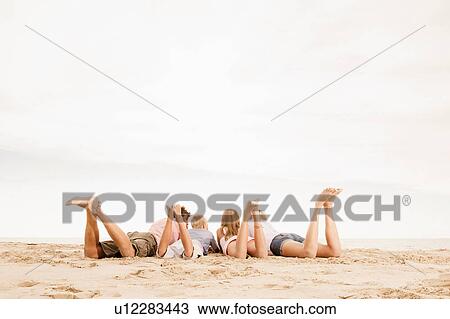 Family lying on beach, legs up View Large Photo Image Stock Image - Family lying on beach, legs up. Fotosearch