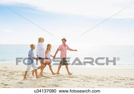 Family walking on beach holding hands View Large Photo Image Stock Image - Family walking on beach holding hands. Fotosearch
