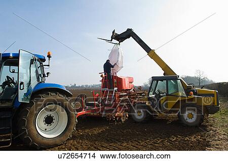 Picture - Farmer filling machinery with seed for planting. Fotosearch