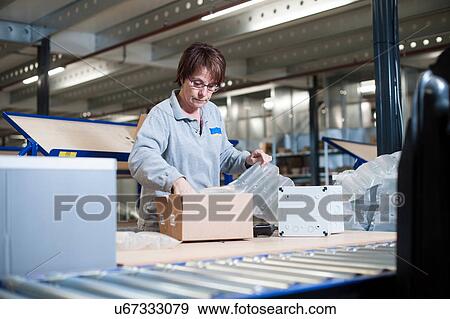 Female warehouse worker packing box for conveyor belt View Large Photo Image Stock Photo - Female warehouse worker packing box for conveyor belt. Fotosearch
