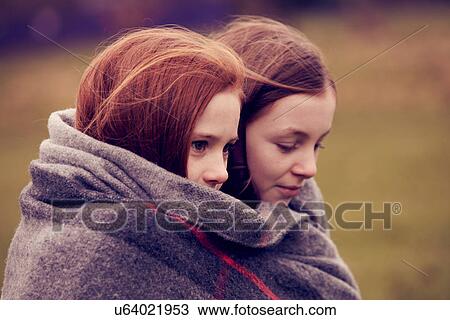 Girls wrapped in a blanket outdoors View Large Photo Image Stock Image - Girls wrapped in a blanket outdoors. Fotosearch