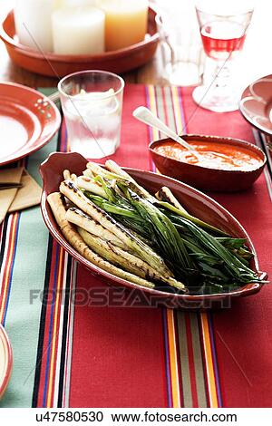 Stock Image - Grilled leeks with spicy sauce. Fotosearch