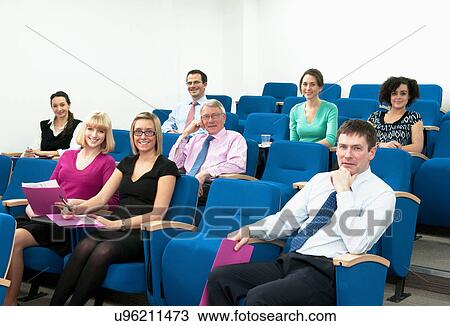 Stock Image - Group of colleagues sitting for presentation. Fotosearch