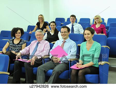 Stock Photograph - Group of colleagues sitting for presentation. Fotosearch