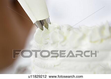 Stock Image - Icing bag and icing, close up. Fotosearch