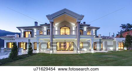 Picture - Illuminated luxury villa at dusk. Fotosearch