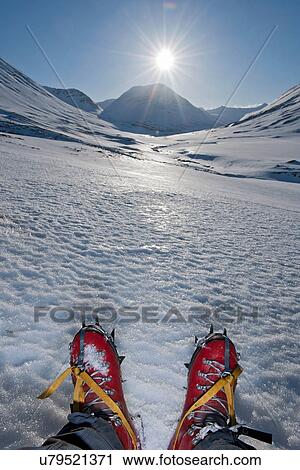 Stock Image - Low section view of mature man sitting in snow covered mountains, Skidadalur, Dalvik, Iceland. Fotosearch