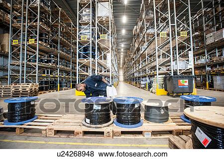 Stock Photo - Male warehouse worker checking pallet order. Fotosearch