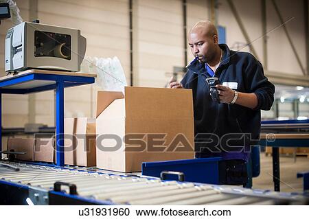 Male warehouse worker checking cardboard box View Large Photo Image Stock Image - Male warehouse worker checking cardboard box. Fotosearch