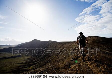 Picture - Man mountain biking, Caldera del Cuchillo, Lanzarote. Fotosearch