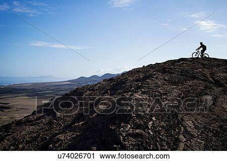 Stock Image - Man mountain biking, Pica del Cuchillo, Lanzarote. Fotosearch