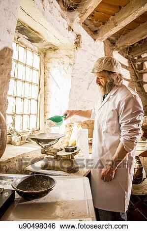 Man scooping flour in windmill View Large Photo Image Stock Photograph - Man scooping flour in windmill. Fotosearch