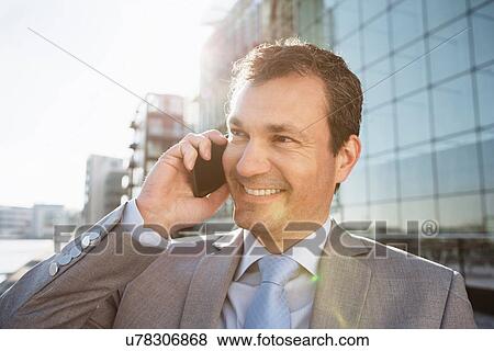 Mature businessman on cellphone in city View Large Photo Image Stock Photo - Mature businessman on cellphone in city. Fotosearch