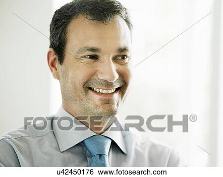 Stock Photograph - Mature businessman smiling and looking away. Fotosearch