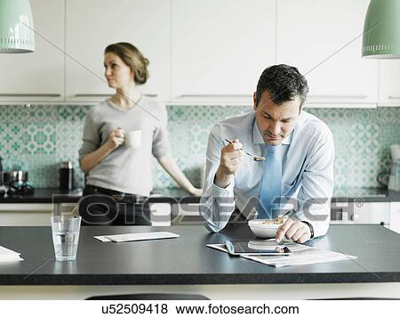 Mature businessman using tablet over breakfast in kitchen View Large Photo Image Stock Photo - Mature businessman using tablet over breakfast in kitchen. Fotosearch