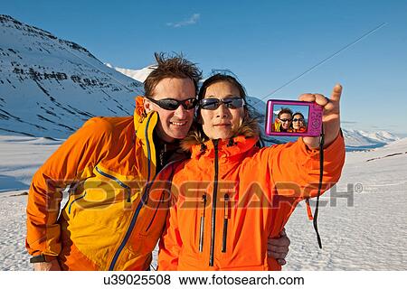 Mature couple taking self portrait in snow covered mountains, Skidadalur, Dalvik, Iceland View Large Photo Image Stock Photo - Mature couple taking self portrait in snow covered mountains, Skidadalur, Dalvik, Iceland. Fotosearch