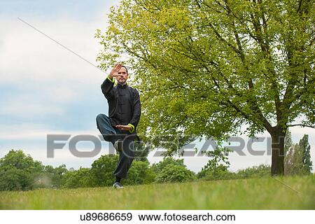 Mature man performing Tai Chi in countryside View Large Photo Image Stock Photo - Mature man performing Tai Chi in countryside. Fotosearch