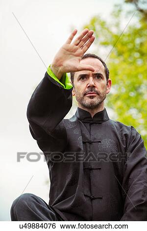 Mature man performing Tai Chi in countryside, front view View Large Photo Image Stock Photograph - Mature man performing Tai Chi in countryside, front view. Fotosearch