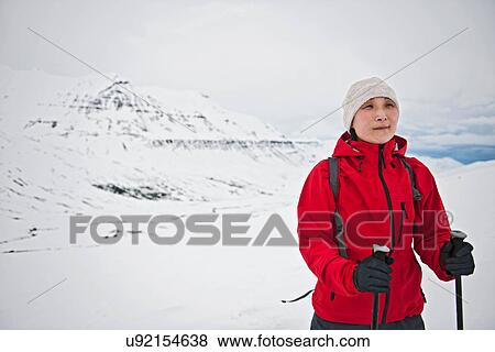 Stock Photo - Mature woman hiking in snowy mountains, Skidadalur, Dalvik, Iceland. Fotosearch
