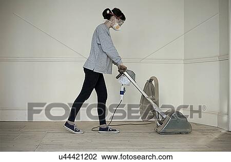 Mature woman sanding floor of new home View Large Photo Image Stock Image - Mature woman sanding floor of new home. Fotosearch