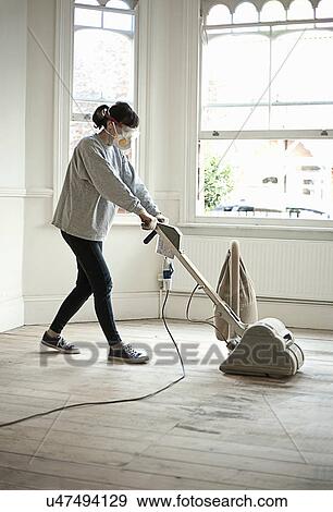 Mature woman sanding floor of new home View Large Photo Image Stock Photo - Mature woman sanding floor of new home. Fotosearch