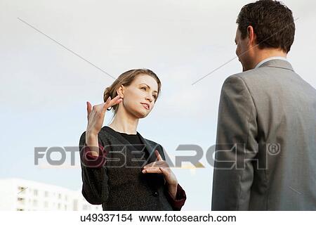 Mid adult businesswoman speaking to colleague outdoors View Large Photo Image Picture - Mid adult businesswoman speaking to colleague outdoors. Fotosearch