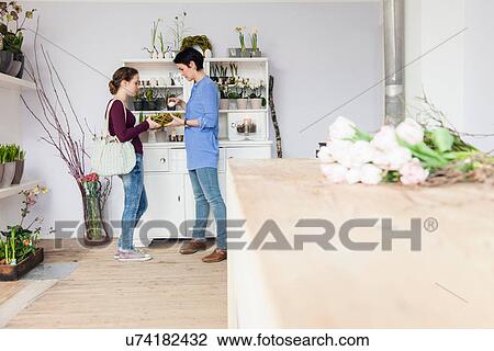 Mid adult woman and teenage girl choosing plant in florists View Large Photo Image Stock Image - Mid adult woman and teenage girl choosing plant in florists. Fotosearch