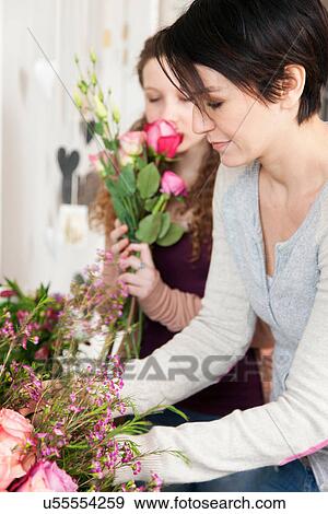 Mid adult woman and teenage girl choosing flowers in florists View Large Photo Image Stock Photo - Mid adult woman and teenage girl choosing flowers in florists. Fotosearch