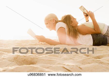 Mother and daughter reading on beach View Large Photo Image Stock Image - Mother and daughter reading on beach. Fotosearch