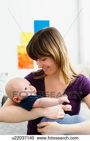 Mother cradling baby son View Large Photo Image Stock Image - Mother cradling baby son. Fotosearch
